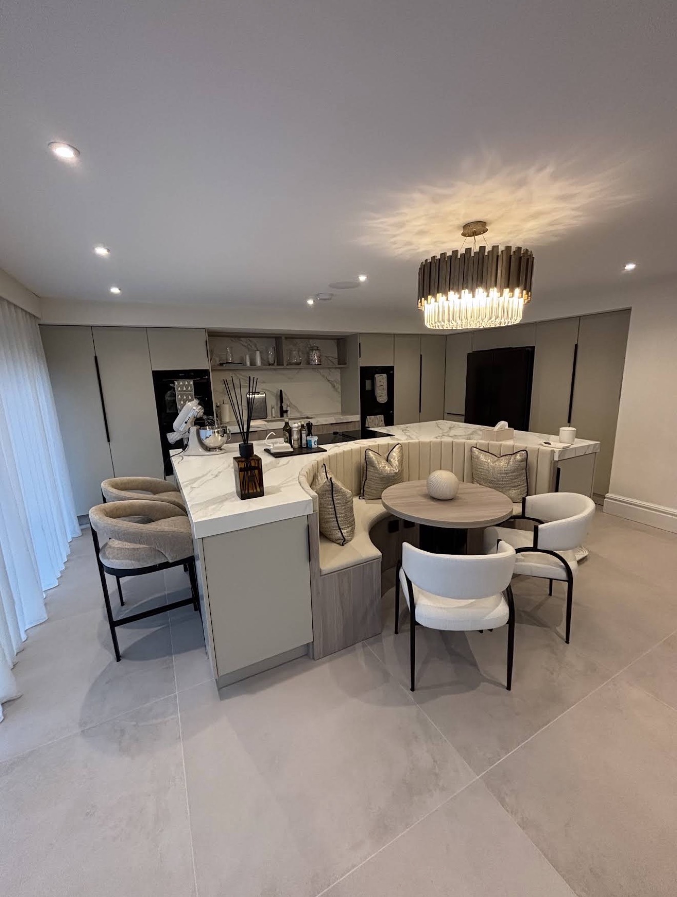 Bespoke fitted kitchen with curved cabinetry and breakfast banquette